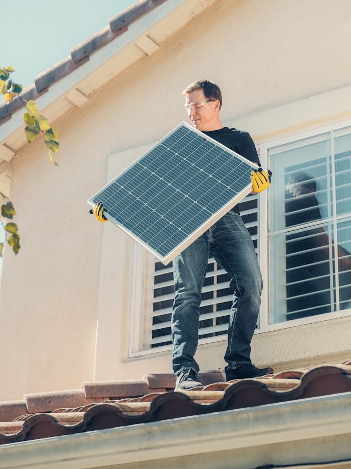 Servicios A technician is installing a solar panel on a house roof, promoting clean energy solutions.